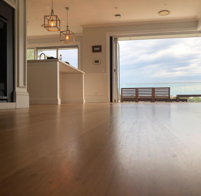 Floor view of elegant house interior with 2 lamps on the left with the balcony view in earth and brown color scheme