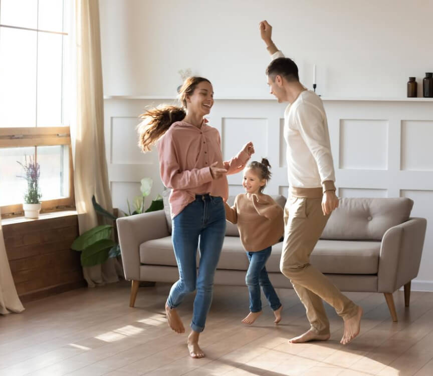 A picture of 2 girls and a man dancing inside the house with the face of a taller girl smiling