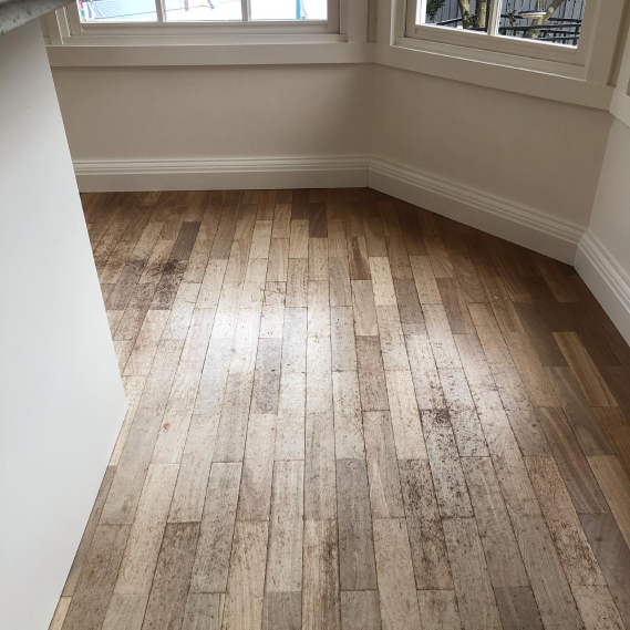 View of a wooden floor with white walls and a window view
